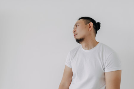 Shrug whatever face Asian man in white t-shirt isolate on white.の写真素材