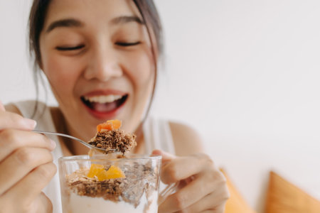 Enjoy face of Asian woman eating dessert made of yogurt. Happy healthy diet.の写真素材