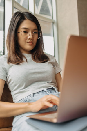 Asian woman focus on working her job online, in the public coffee cafe.の写真素材