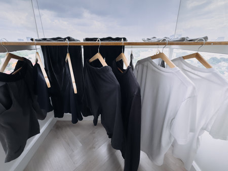 Black and white clothes are hanging at the balcony in the cloudy day.の写真素材