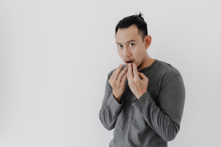 Cold Asian man in grey fleece base layer stand chilling isolate on white.