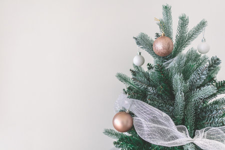 Decorated Christmas pine tree decorated with white gold ornaments and garlands isolated on white wall cerebrate for happy holiday and new yearの写真素材