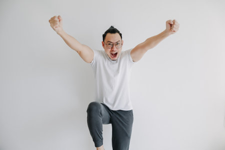 Cheerful happy Asian man pose isolate on white, concept of win and victory.