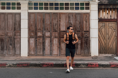 Tourist backpacker Asian man resting drinking water as the sun is too hot.の写真素材