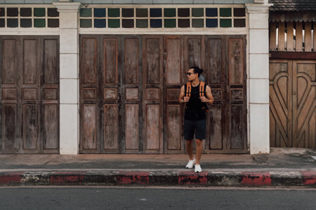Asian Tourist backpacker man crossing street in local Asia old town.の写真素材