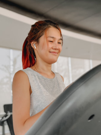 Portrait of Asian woman walking on the treadmill in the gym.の写真素材