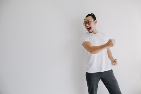 Cheerful happy Asian man pose isolate on white, concept of win and victory.の写真素材