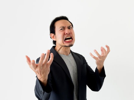 Angry and furious Asian business man isolated on white background.の写真素材
