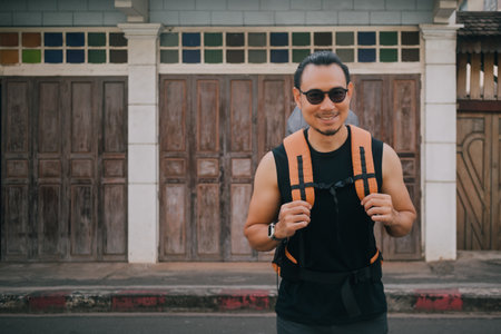 Asian Tourist backpacker man crossing street in local Asia old town.