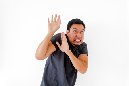 Funny asian man doing scary face and acting isolated on white background.