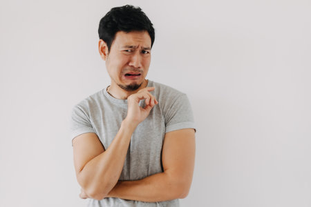 Young Asian male expresses repulsion through exaggerated facial reactionの写真素材