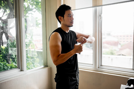 Fit male preparing to drink water in gym break with outdoor viewの写真素材