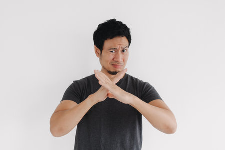 Asian male expressing strong disagreement using crossed arm gesture in studioの写真素材