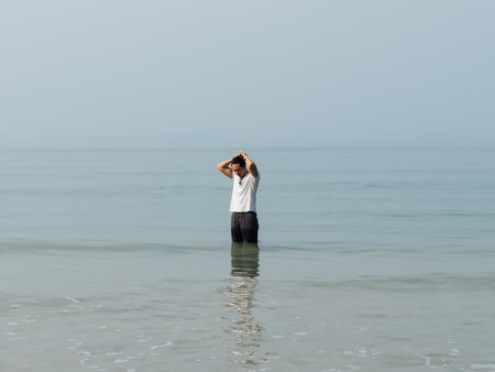 Asian ma chilling on the beach with clear water in sunny day in Thailand.の写真素材