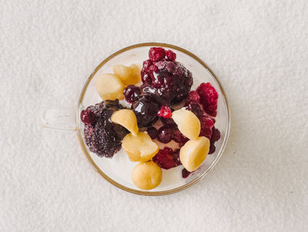Bowl of yogurt served with grapes and berries on white backgroundの写真素材