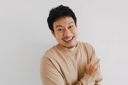 Young Asian male shows humorous expression while leaning forward playfullyの写真素材