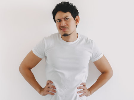 Thai male with medium build and short black hair placing hands on waist and standing confidently...