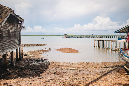 Rustic coastal view with wooden houses and fishing pier under cloudy skyの写真素材