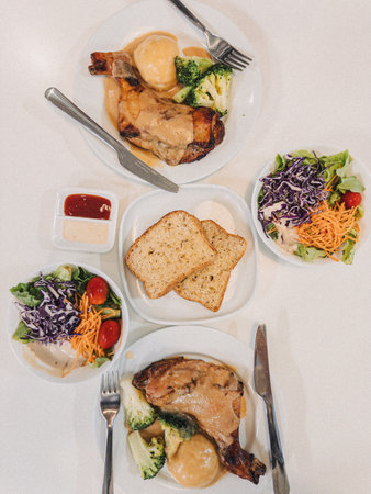 A wonderfully delicious family dinner meal that features perfectly roasted chicken, fresh mixed salads, and warm breadの写真素材