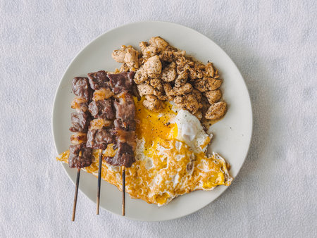 Keto protein meal of beef skewer with fried egg and chicken breast.の写真素材
