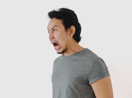 A man is passionately expressing intense anger with a fierce and animated facial expression along...