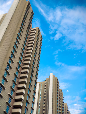 A stunning skyward view showcases modern residential highrises beautifully set against a vivid blue...