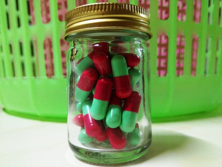 Red and Green Capsule in the Bottleの写真素材
