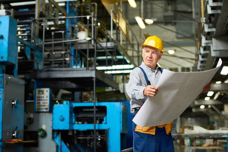 Senior Construction Worker Holding Floor Plansの写真素材