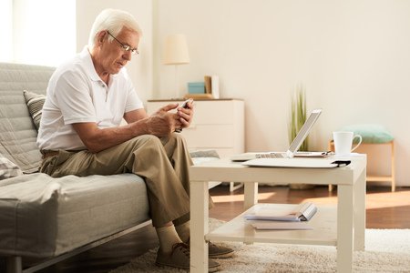 Senior Man Using Smartphone at Homeの写真素材