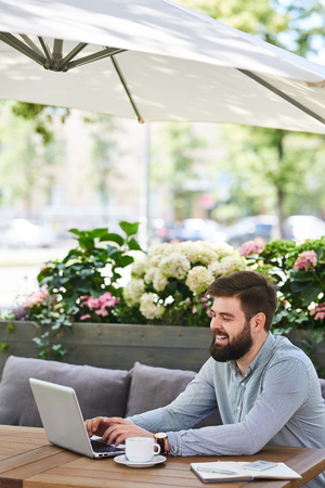 Smiling Bearded Businessman Working in outdoor Cafeの写真素材