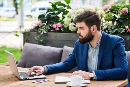 Bearded Businessman Working in Cafe Outdoorsの写真素材