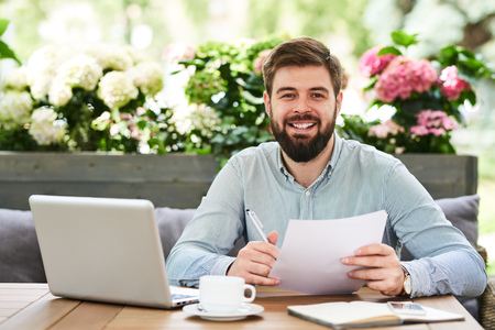 Smiling Entrepreneur Working in Cafe  Outdoorsの写真素材