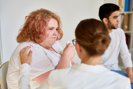 Obese Young Woman Crying in Support Group Sessionの写真素材