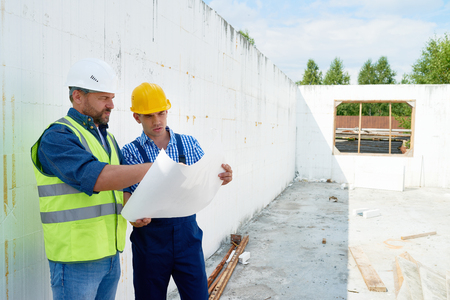 Construction Worker Discussing Floor Plans with Supervisorの写真素材