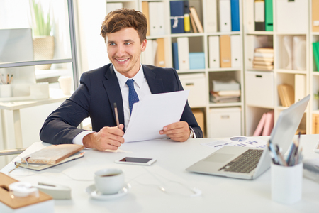 Happy Businessman Reading Documentsの写真素材