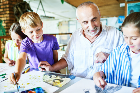 Little pupils gathered together at art studio and sharpening drawing skills, their senior teacher...