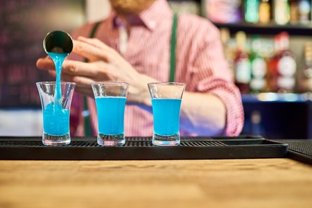 Bartender  Pouring Vodka Shots at Bar Counterの写真素材