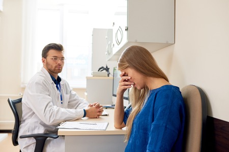 Sad Young Woman in Doctors Officeの写真素材