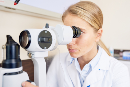 Female Ophthalmologist Looking in Slit Lampの写真素材