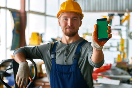 Young Workman Presenting Mobile Appの写真素材
