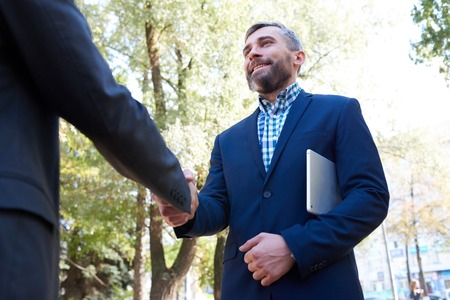 Mature Businessman Shaking Hands with Partner