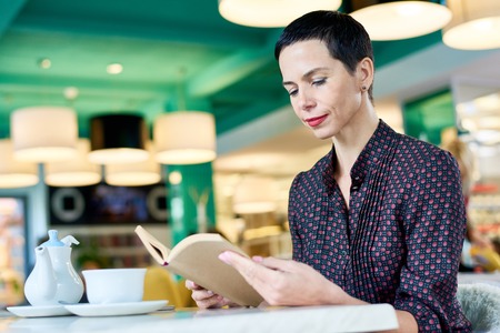 Elegant Woman Reading Book in Cafe