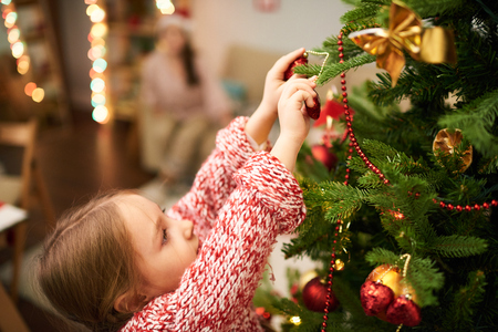 Cute Girl Decorating Christmas Treeの写真素材