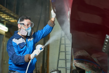 Worker Spray Painting Boats in Workshopの写真素材