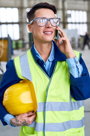 Modern Woman Speaking by Phone at Factoryの写真素材