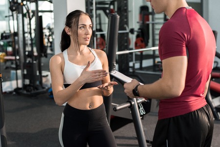 Pretty Young Woman Talking to Fitness Coach