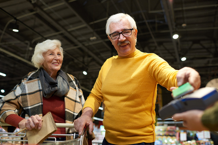 Senior Couple Paying in Supermarketの写真素材
