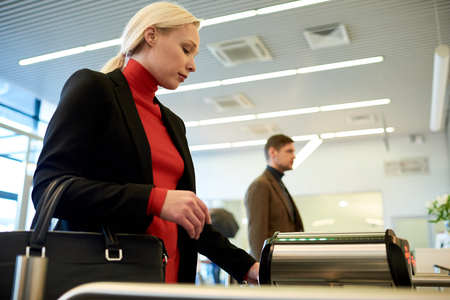 Blonde Businesswoman Passing Turnstile