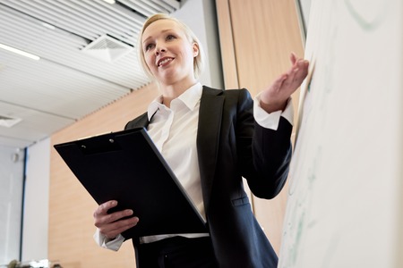 Young Businesswoman Presenting Project at Whiteboardの写真素材