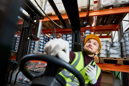 Warehouse Worker Moving Goods Using Forklift